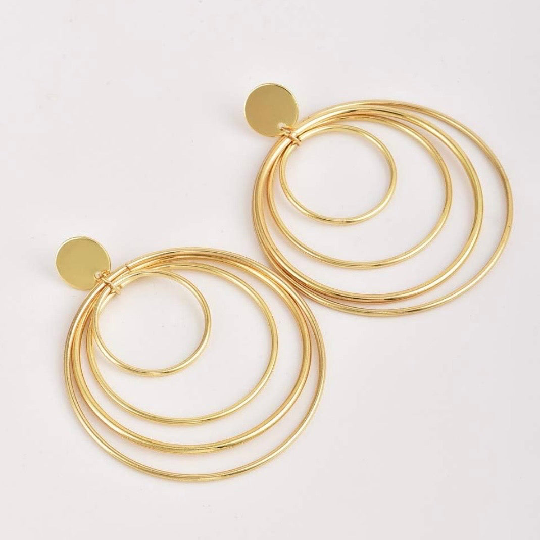 Golden Circles Dangle Earrings with four layered gold circles and polished round stud on a white background.