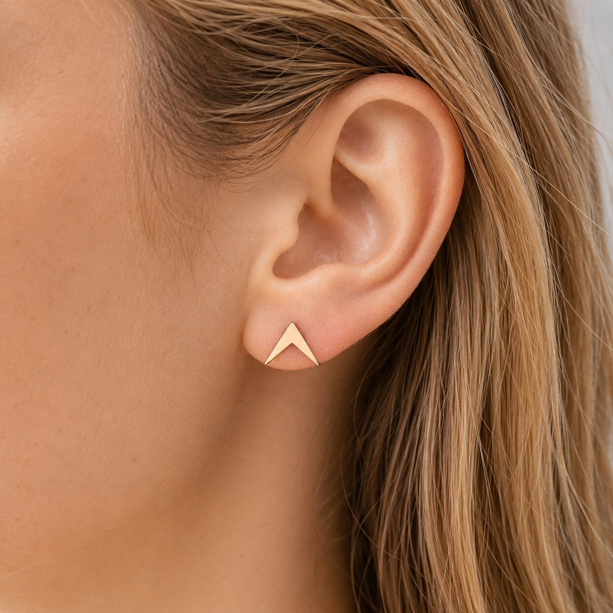 Woman wearing Golden Geometric Stud Earrings, minimalist gold stud earrings with a modern geometric design.