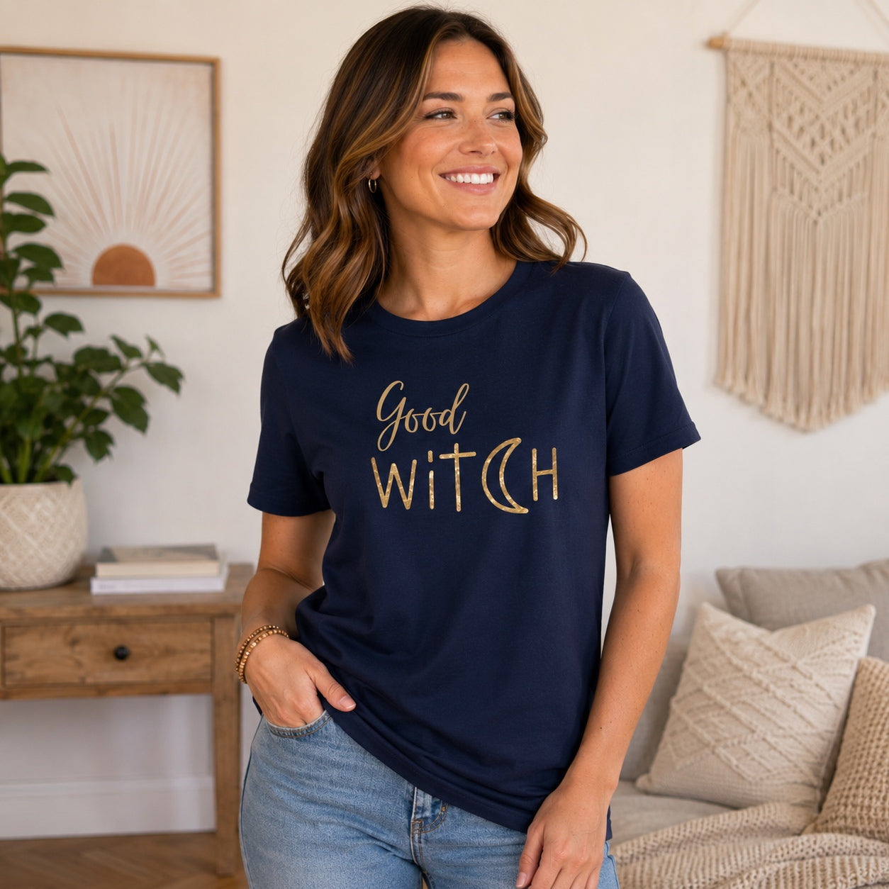 Woman wearing the Good Witch T-Shirt in navy with metallic gold lettering in a bright modern home.