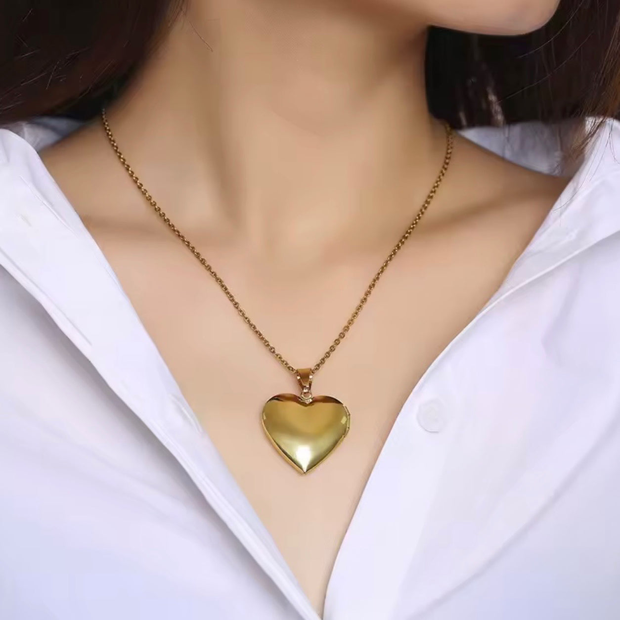 Woman wearing the gold Heart Locket Necklace with a polished heart-shaped pendant.