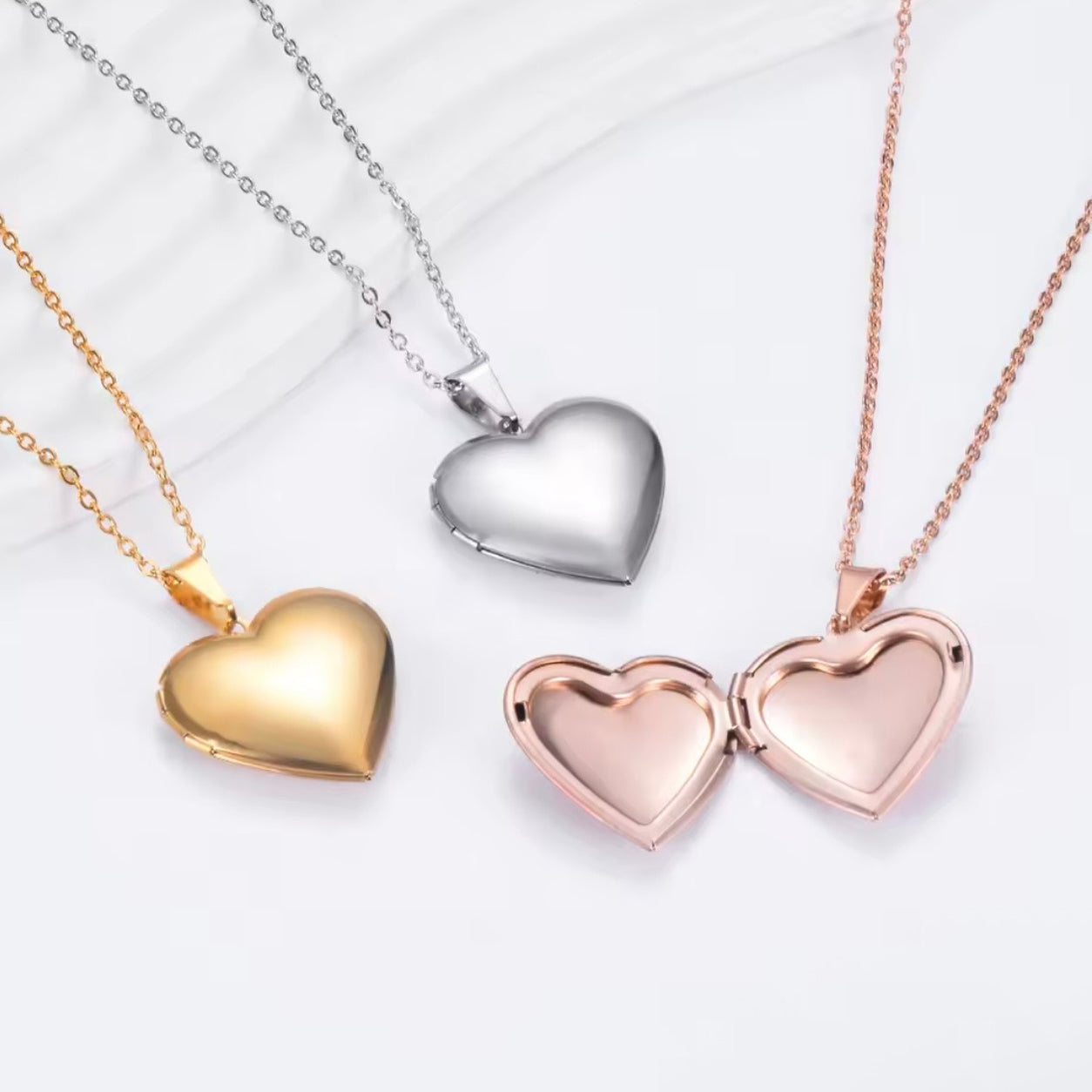 Heart Locket Necklace shown closed in gold and silver with rose gold locket opened to display the photo compartment.