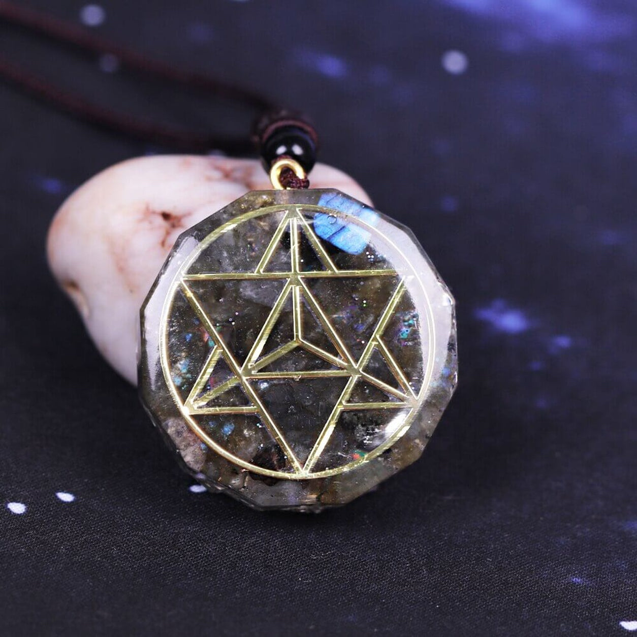 Labradorite Merkaba Pendant Necklace displayed on a natural stone, highlighting the shimmering crystal and geometric design.