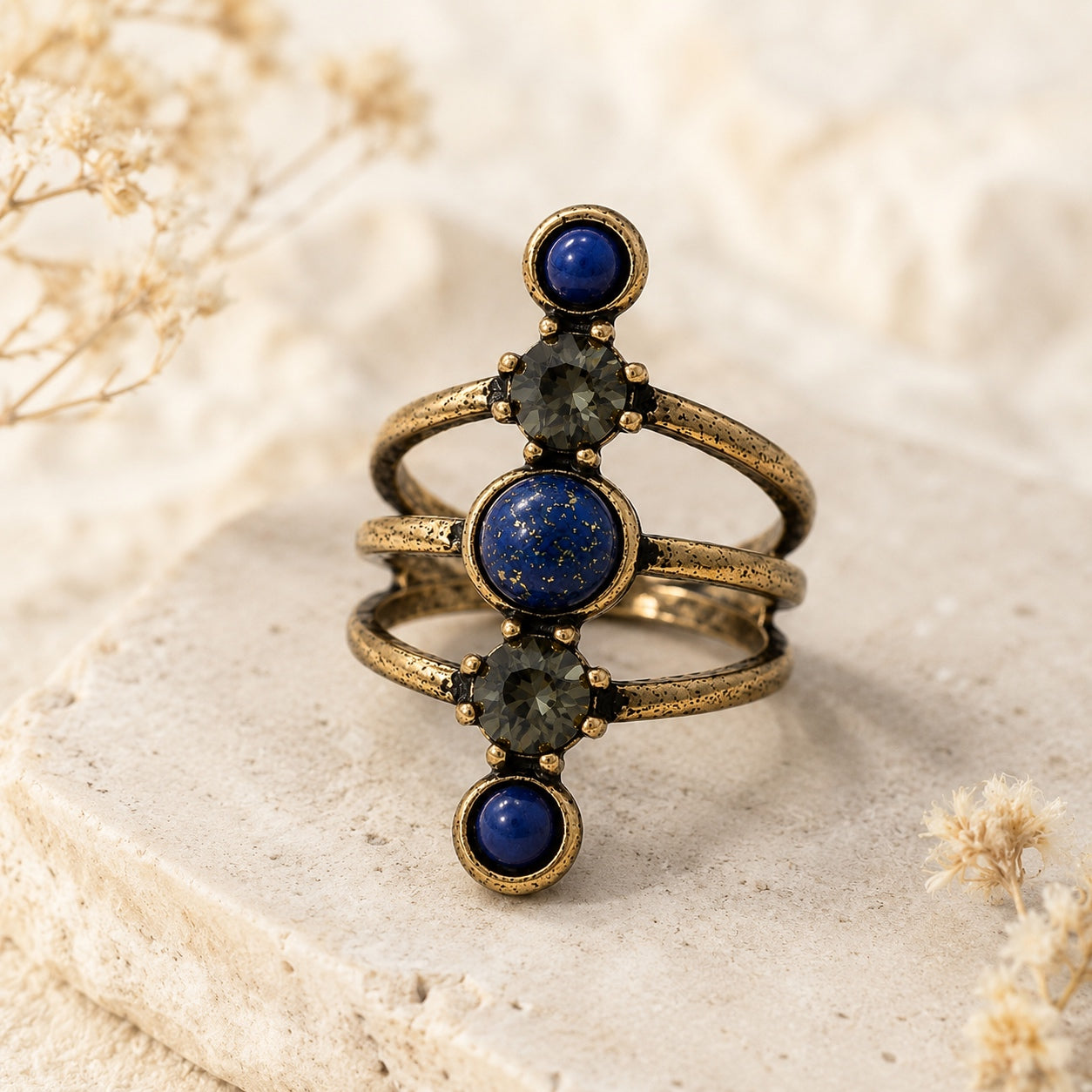 Lapis Lazuli Stone Ring with an antique bronze finish featuring deep blue lapis lazuli stones and crystal accents on a neutral display.