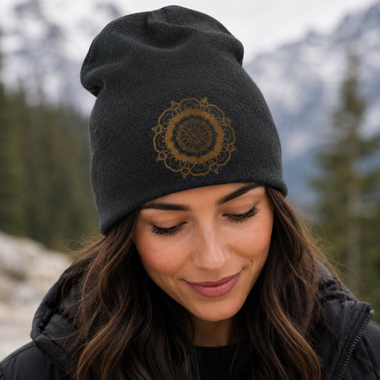 Woman wearing the Mandala Beanie Hat in charcoal gray with a bronze mandala design during an outdoor mountain adventure.