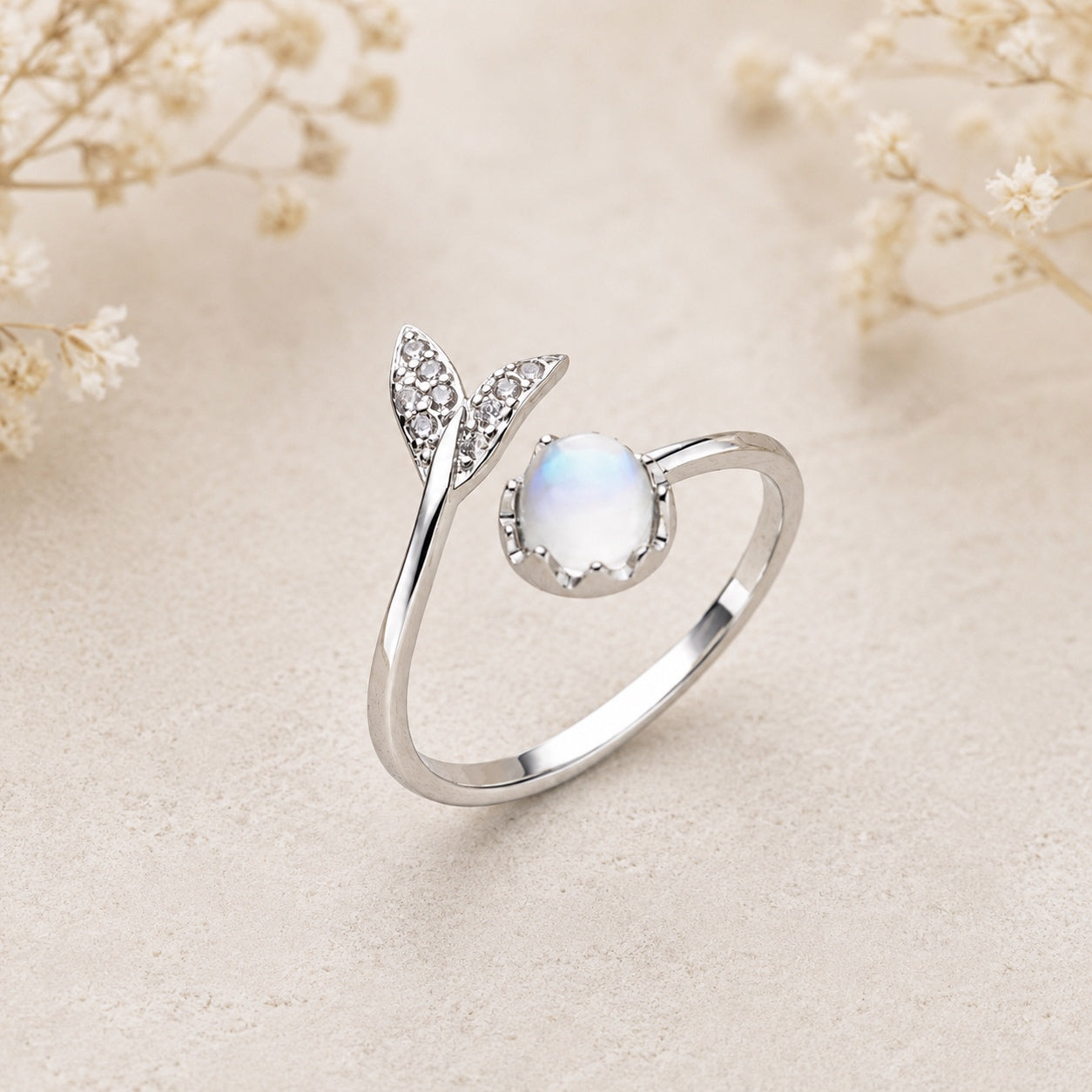 Mermaid Moonstone Ring featuring an iridescent moonstone, sparkling leaf accents, and an adjustable silver open band.