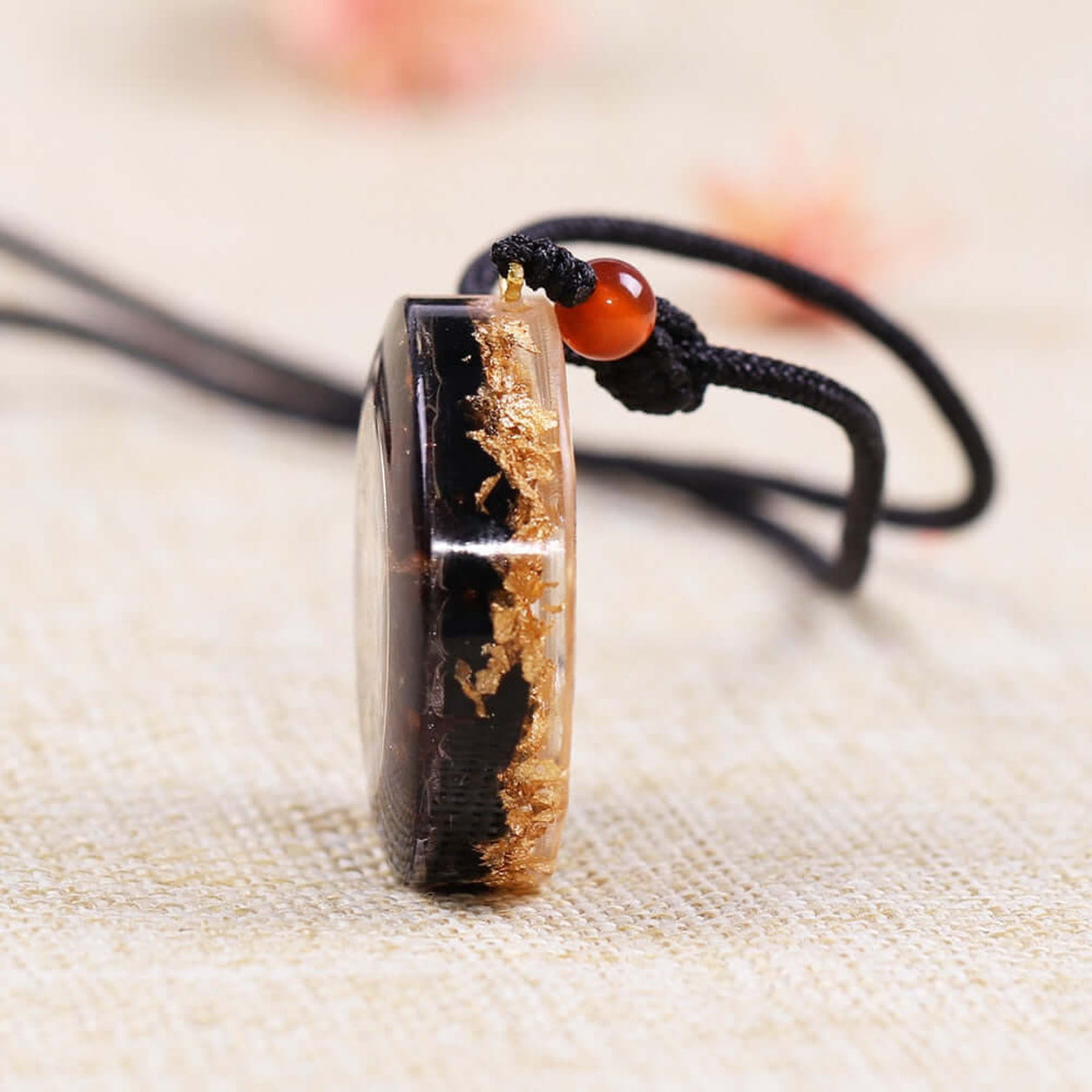 Side profile of Metatron’s Cube Obsidian Pendant Necklace showing handcrafted resin, obsidian, and gold leaf detail.