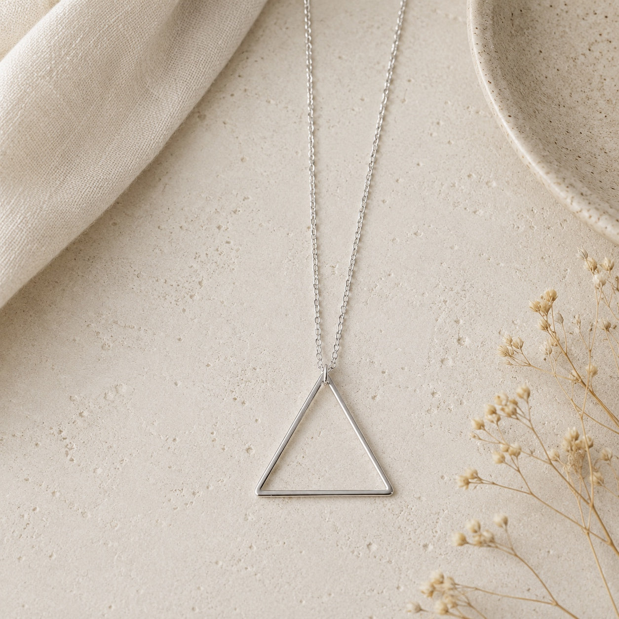 Silver Minimalist Triangle Pendant Necklace featuring a modern geometric triangle pendant on a fine chain.