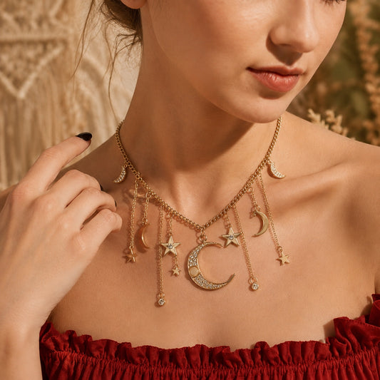 Woman wearing the Moon & Stars Charm Necklace, a gold layered celestial necklace with crescent moon, star charms, crystal accents, and dangling chains in a boho-inspired close-up.