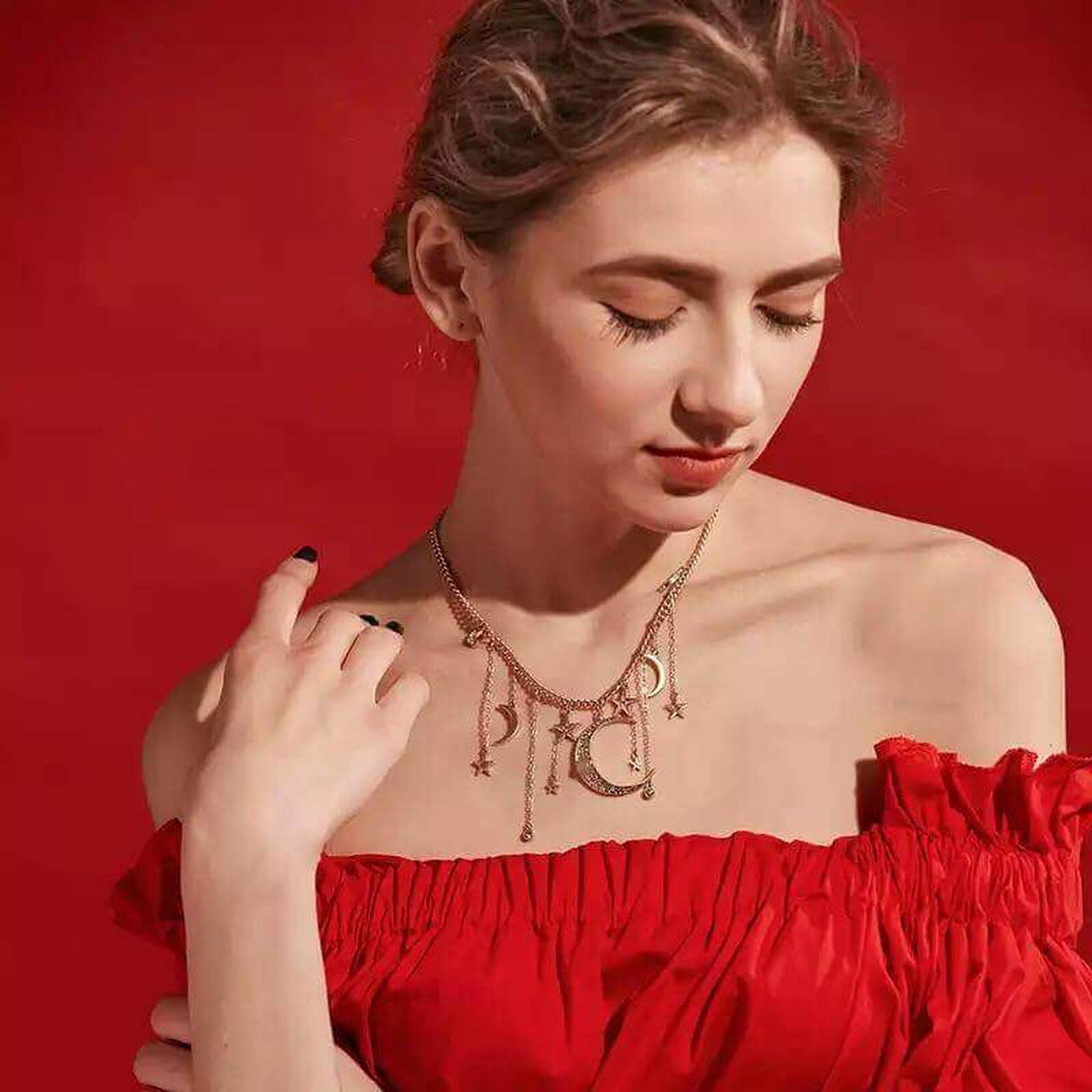 Woman wearing celestial moon and star necklace with gold charm details