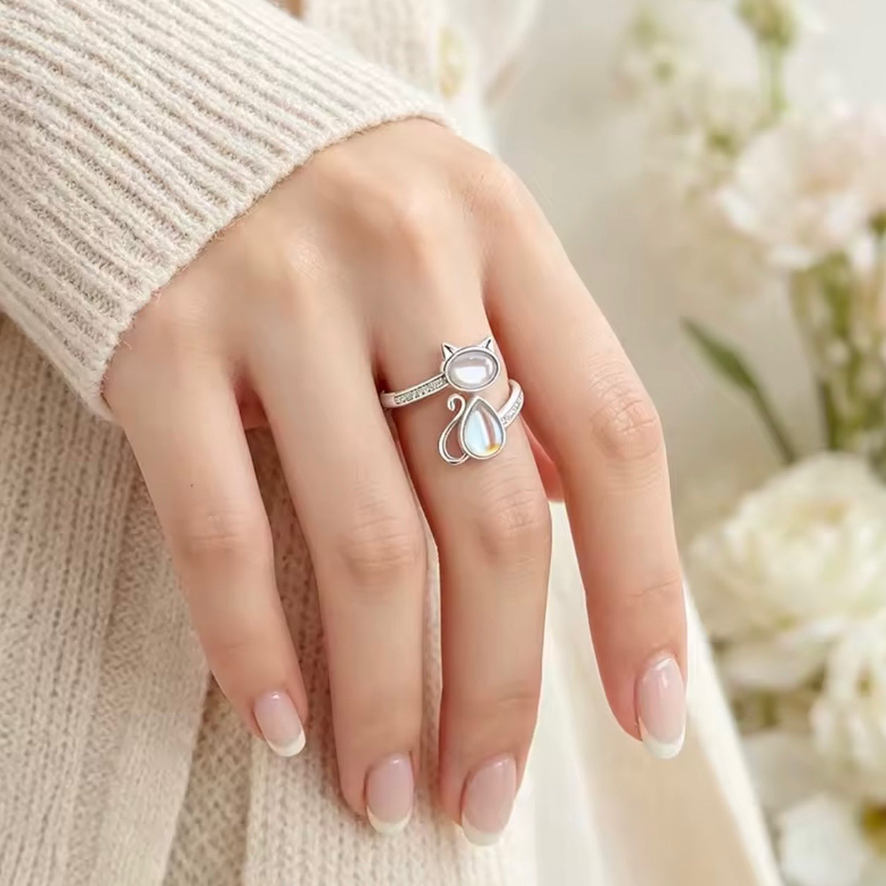 Woman wearing the Moonstone Cat Ring on her finger, showing the elegant adjustable fit and cat-inspired design.