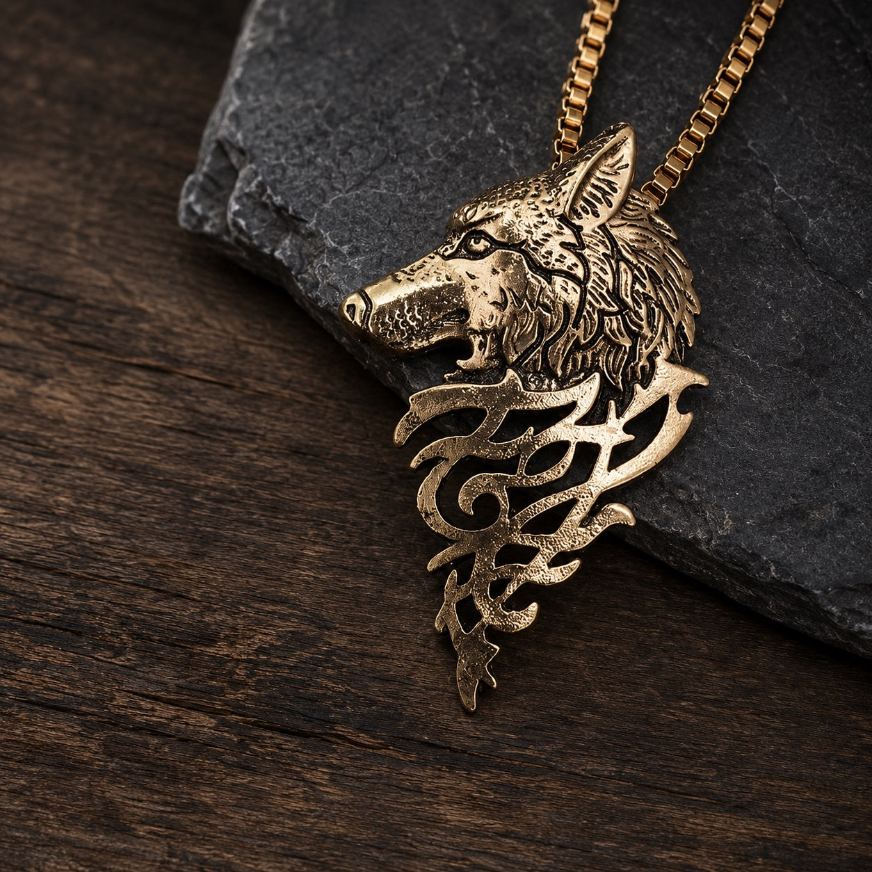 Gold Mystic Wolf Pendant Necklace resting on natural stone, highlighting the detailed wolf pendant and long box chain.