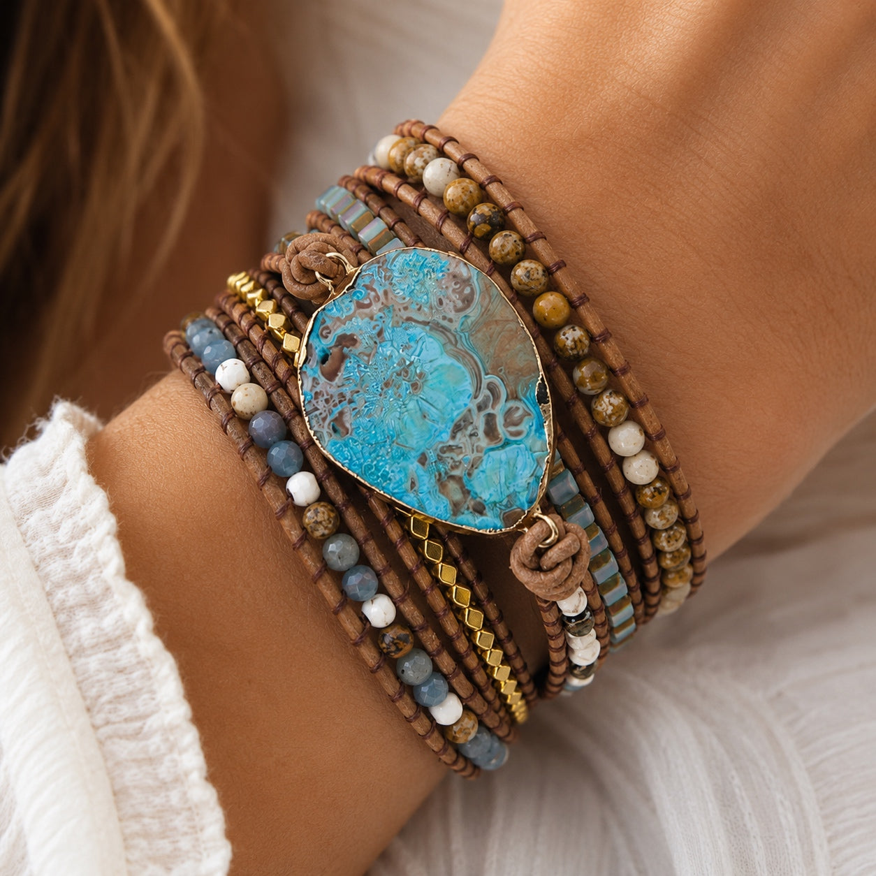 Close-up of a woman wearing the Ocean Jasper Wrap Bracelet featuring natural ocean jasper, gemstone beads, leather wrap, and gold accents.