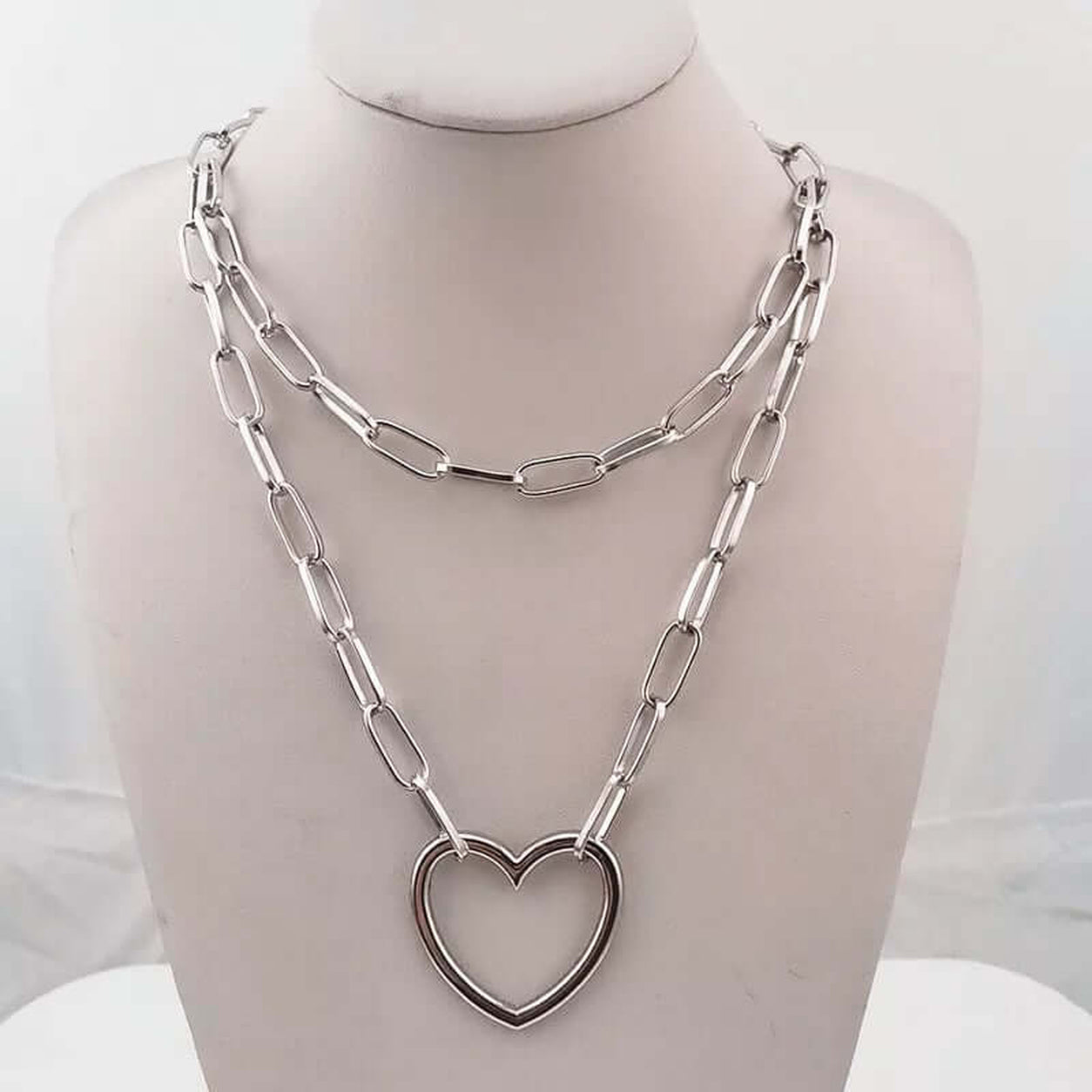 Open Heart Chain Necklace in silver displayed on a jewelry bust featuring a layered paperclip chain and open heart pendant.
