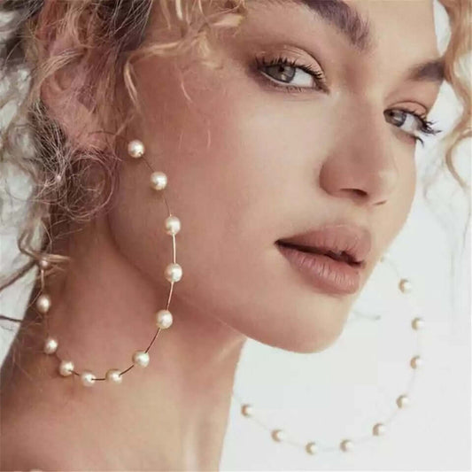 Model wearing elegant Pearl Hoop Earrings featuring delicate faux pearls on oversized minimalist hoops.