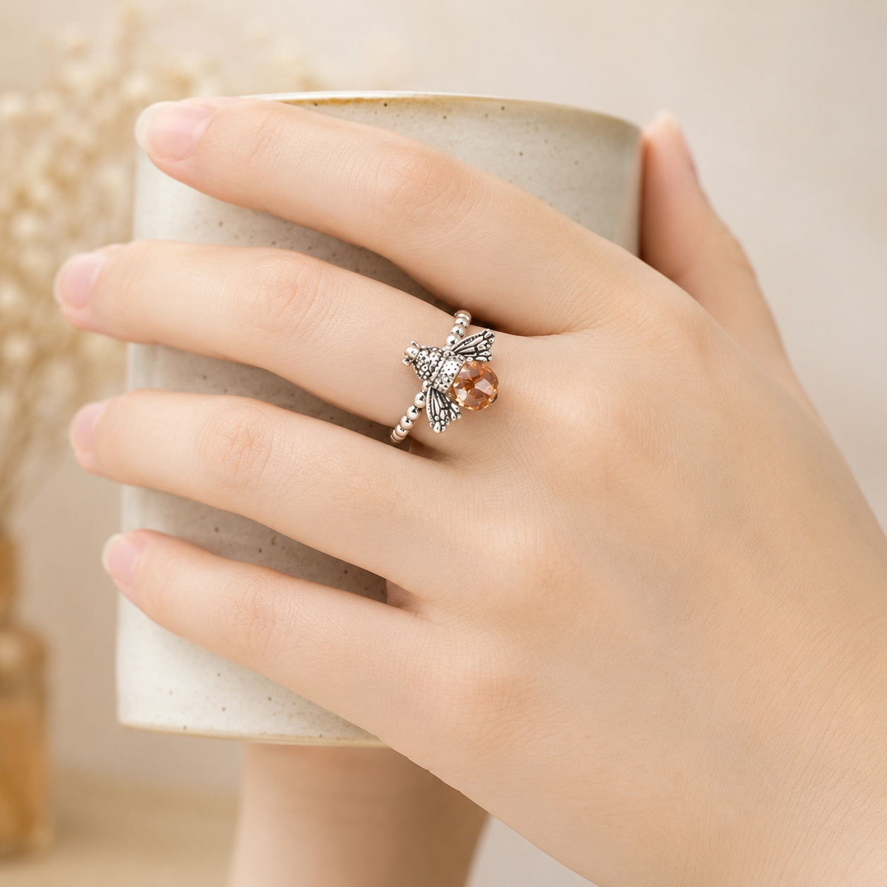 Queen Bee Ring worn on hand showing the silver honey bee design and faceted amber-colored stone.