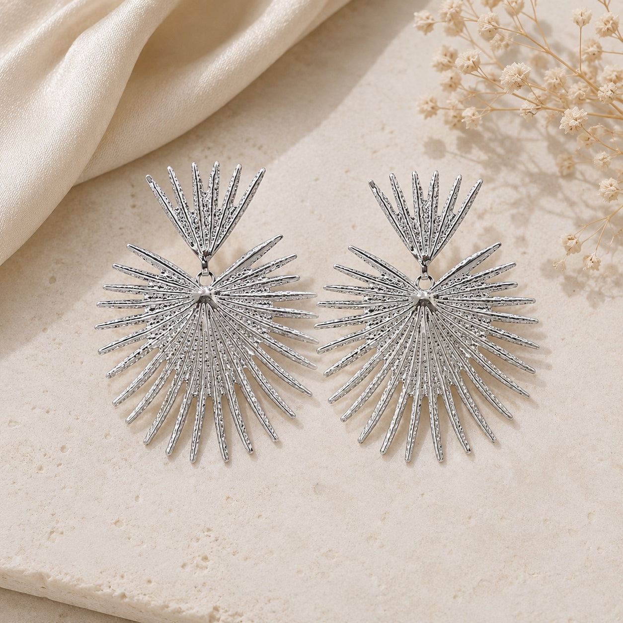 Silver Queen Of Hearts statement earrings featuring a textured sunburst fan design with lightweight oversized drop style for elegant everyday or evening wear.