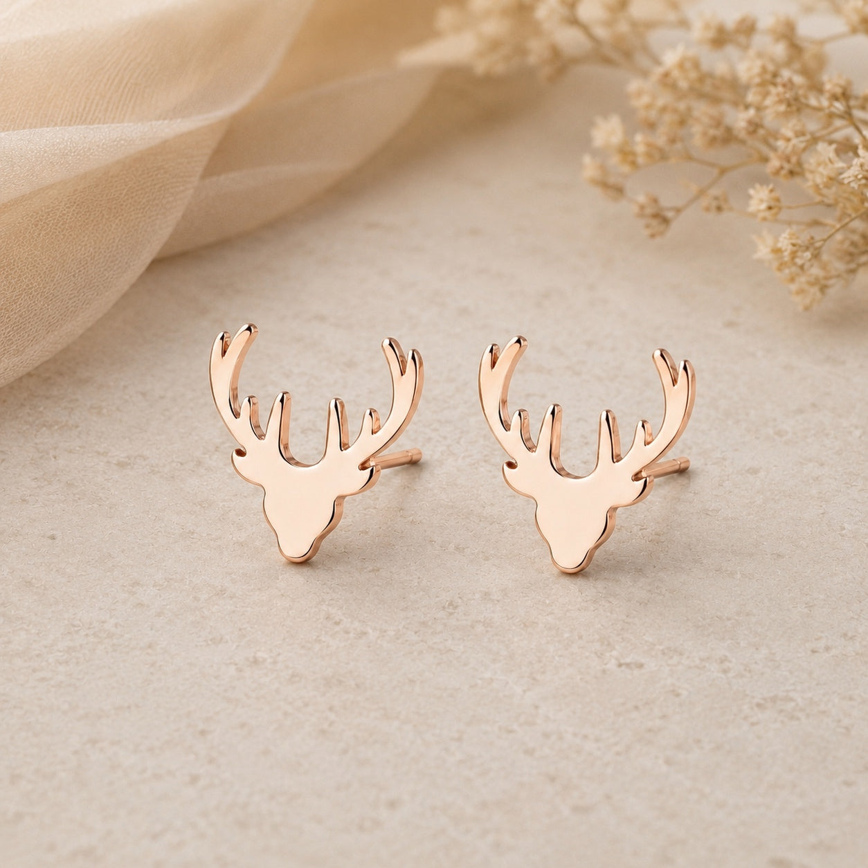 Rose gold deer antler earrings with a simple nature-inspired design.