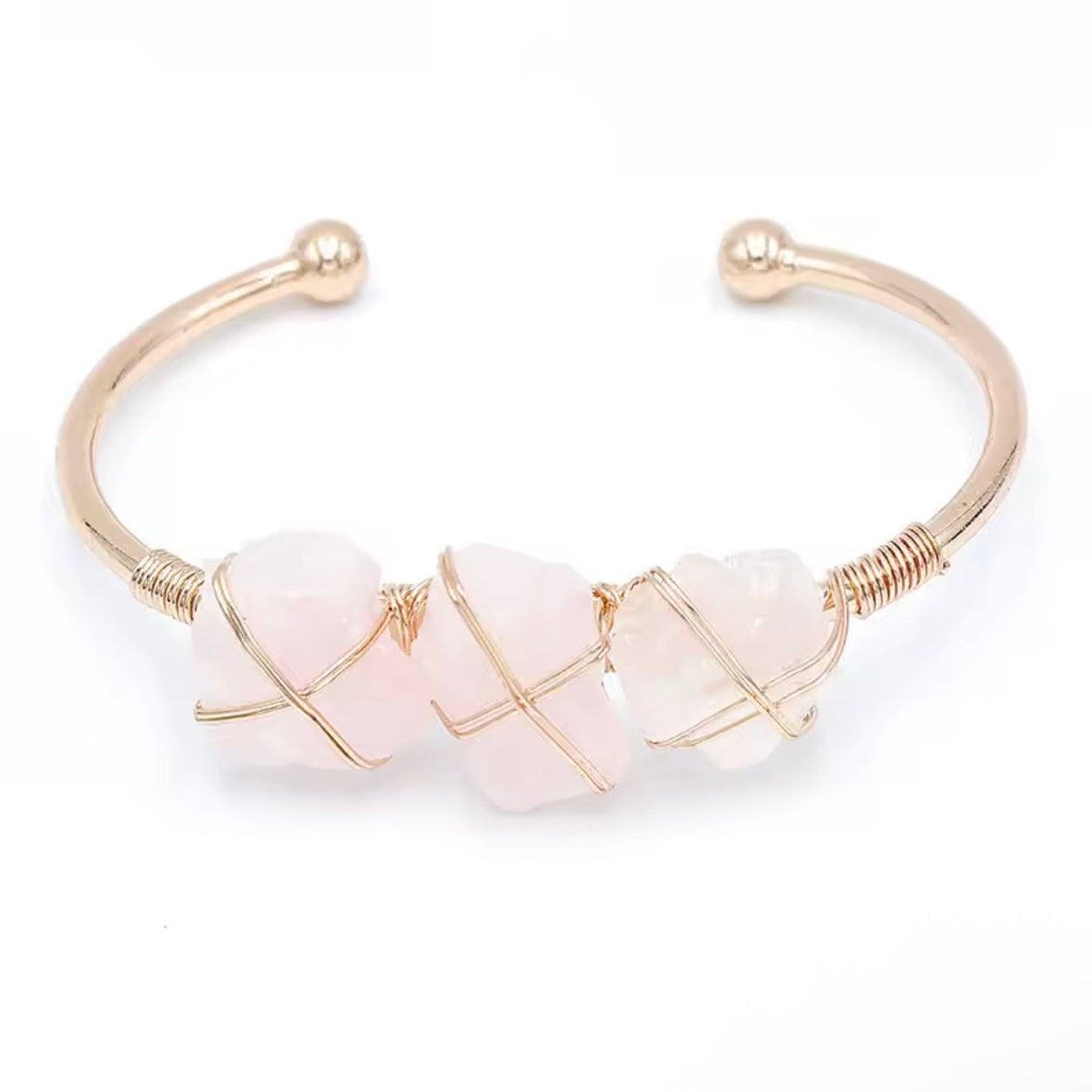 Rose quartz stone cuff bracelet with three pink stones wrapped in gold wire.