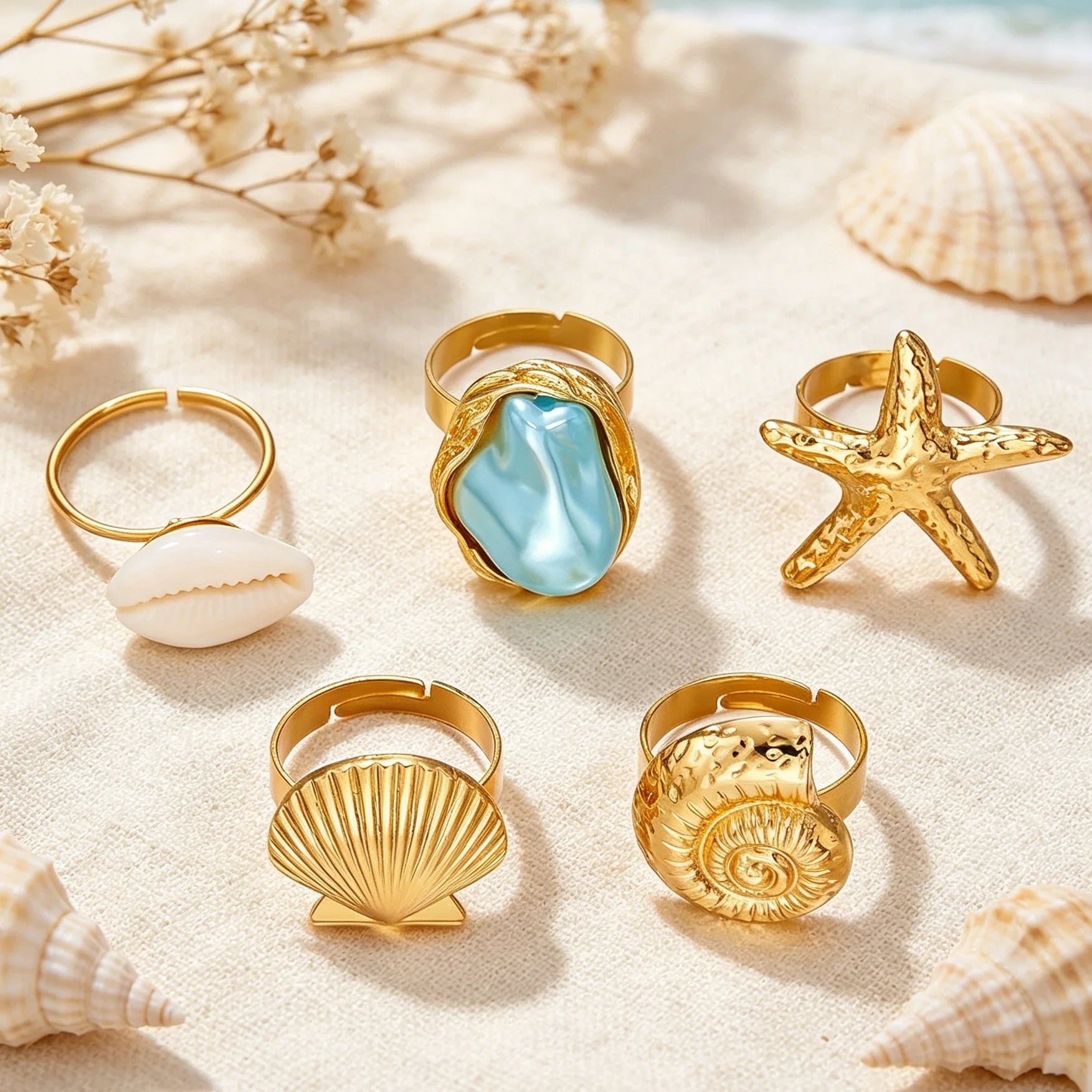 Seaside Treasures Ring Set featuring gold-tone starfish, seashell, cowrie shell, and aqua statement rings in a coastal-inspired flat lay.