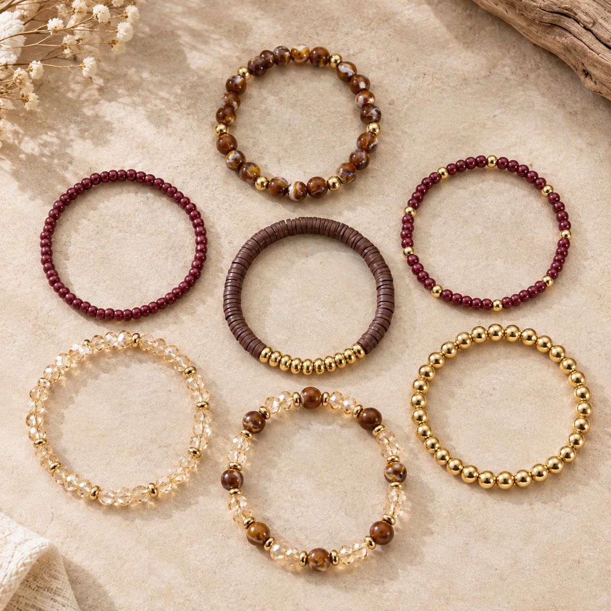 Seven individual Sedona Spirit beaded stretch bracelets arranged flat, with brown marbled, burgundy, champagne and gold-tone beads.