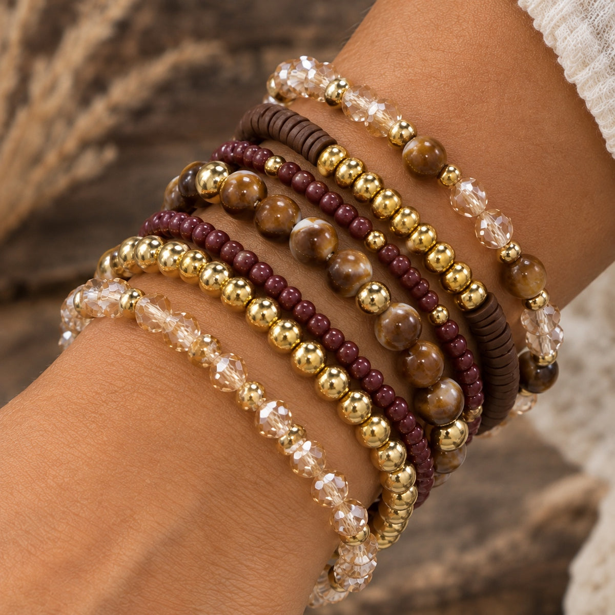 Brown and gold Sedona Spirit beaded bracelet set with burgundy beads and champagne faceted beads stacked on a wrist.