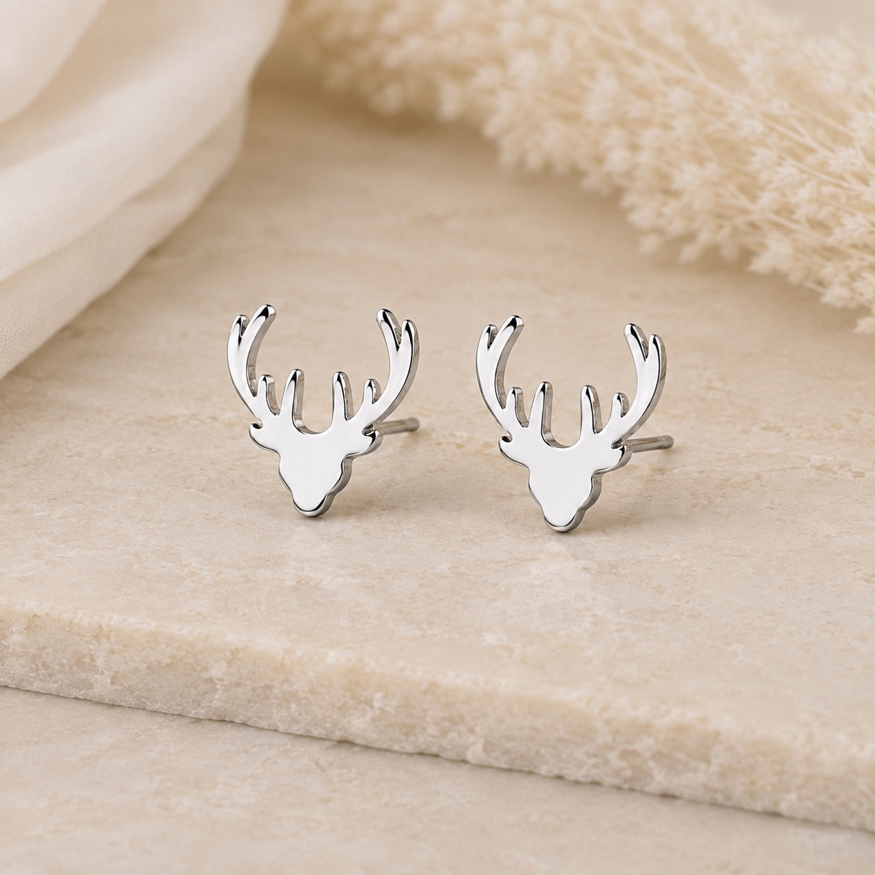 Silver deer antler stud earrings with polished finish.