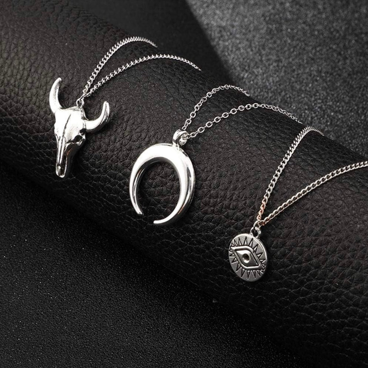 Silver Layered Boho Necklace featuring evil eye, crescent horn, and bull skull pendants on layered chains.