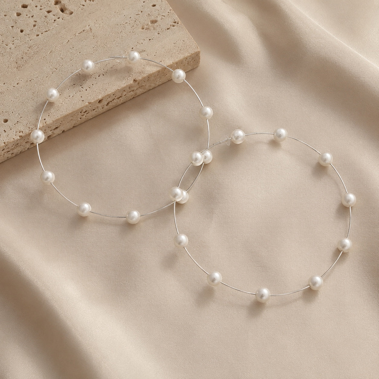Silver Pearl Hoop Earrings featuring delicate faux pearl accents in a lightweight modern hoop design.