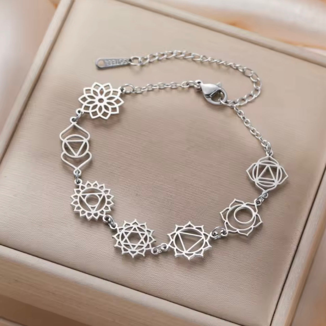 Silver Seven Chakras bracelet featuring seven chakra symbols flat lay on jewelry box.