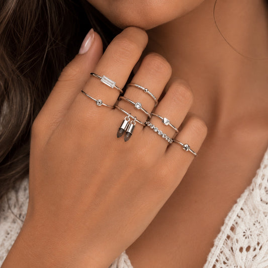 Woman wearing Silver Stacking Ring Set featuring crystal, rhinestone and natural stone charm rings.