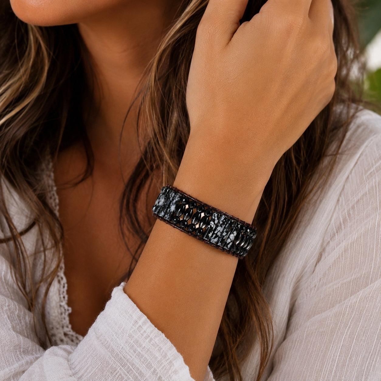 Woman wearing the Snowflake Obsidian Bracelet featuring polished snowflake obsidian and black gemstone beads.