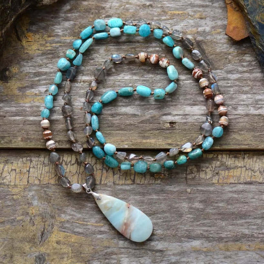 Spirit Stone Beaded Necklace featuring turquoise gemstone beads, labradorite beads, and a natural teardrop stone pendant on a rustic wood background.