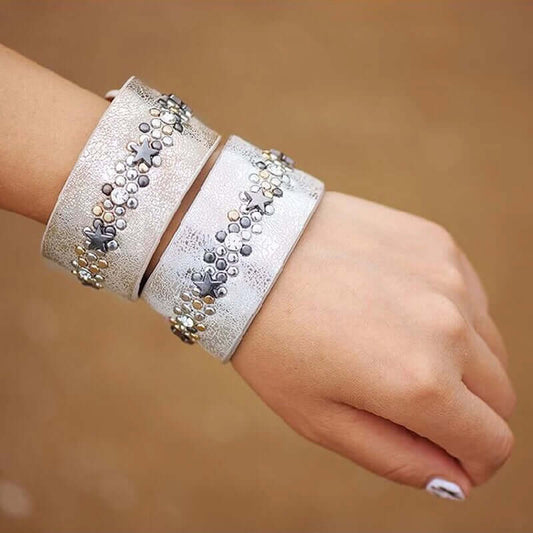 Woman wearing the Star Charm Cuff Bracelet Set featuring silver star charms, crystal accents and a wide metallic cuff.