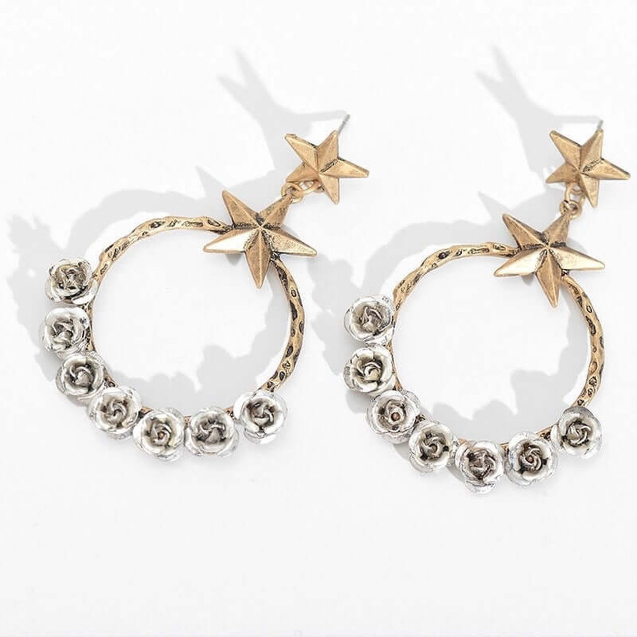 Starry Desert Rose Earrings with antique gold stars and silver rose hoop design shown on a white background.
