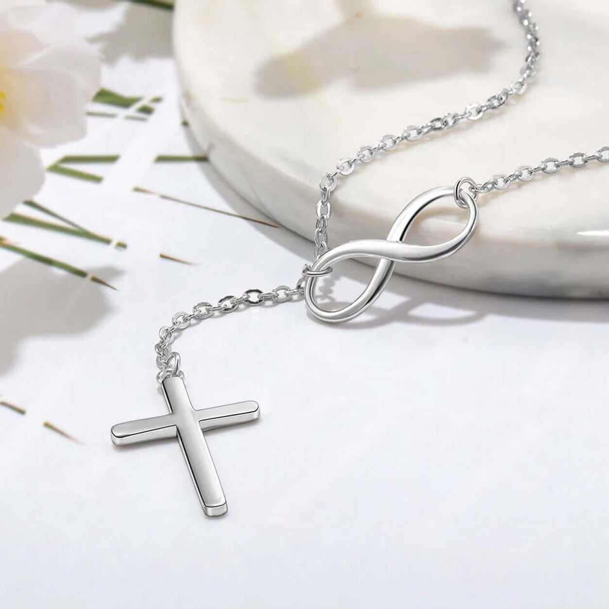 Close-up of the sterling silver Infinity Cross Necklace highlighting the polished infinity symbol, chain, and cross pendant.