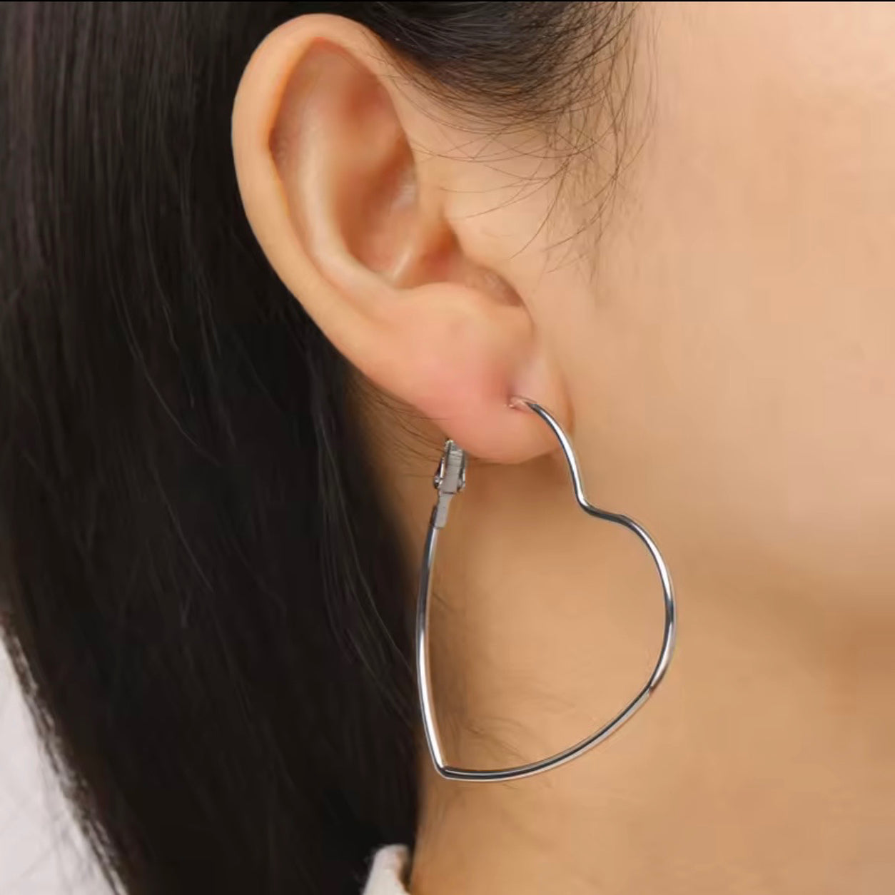 Close-up of a woman wearing a Timeless Heart Hoop Earring.