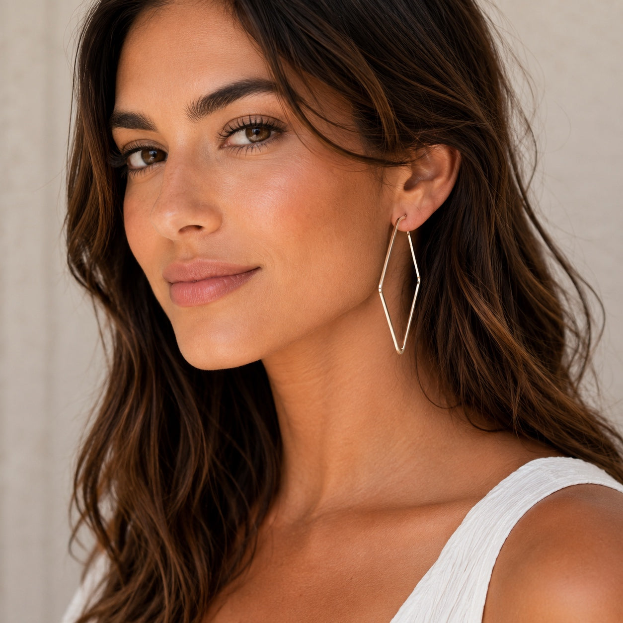 Woman wearing Timeless Square Hoop Earrings in silver featuring a lightweight geometric square hoop design for everyday wear.