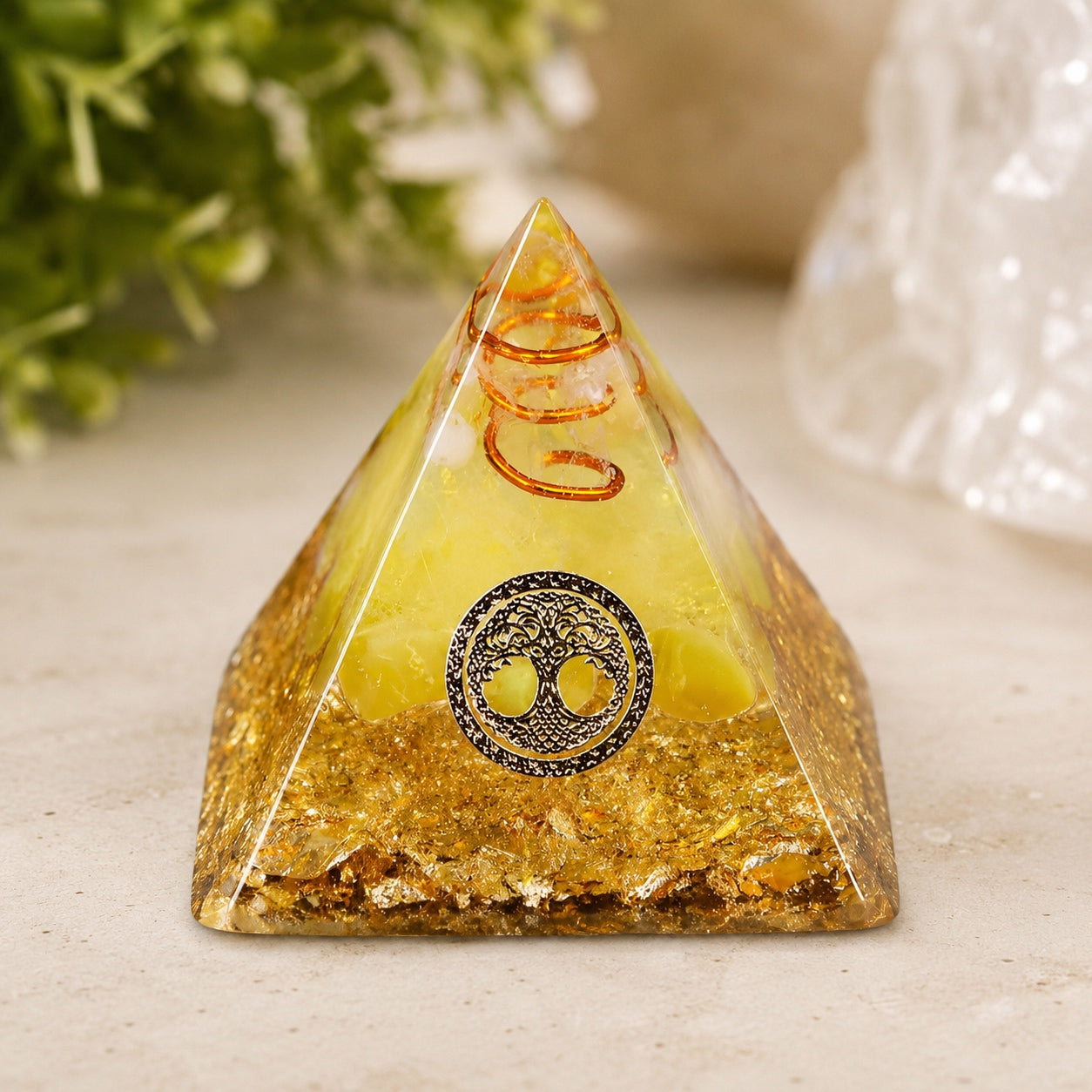 Tree of Life Agate Crystal Pyramid with copper coil, white crystal, and gold foil displayed on a natural stone surface.