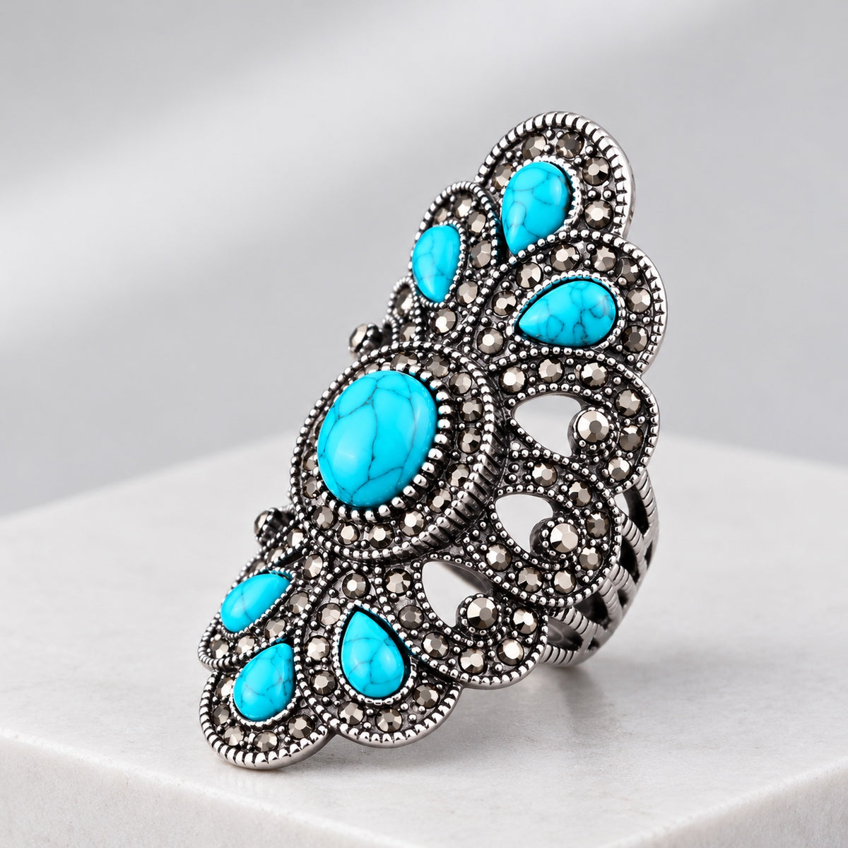 Ornate vintage turquoise statement ring with antique silver filigree, gray crystal accents and oval turquoise stones.