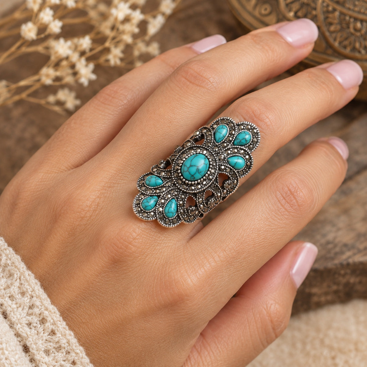 Vintage Turquoise Statement Ring featuring turquoise stones and ornate antique silver detailing, shown on a woman’s hand.